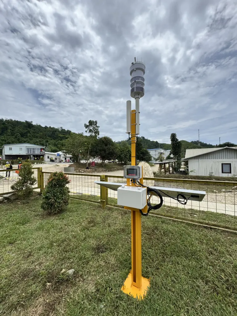 Illustration of a high-tech tipping bucket Automatic Rainfall Recorder device by Fortuna Argatech installed in an agricultural field.
