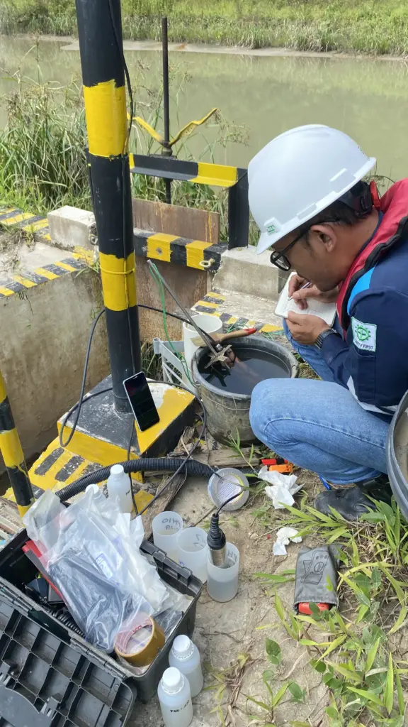 A Fortuna Argatech technician performing calibration on a water monitoring sensor in an industrial area.